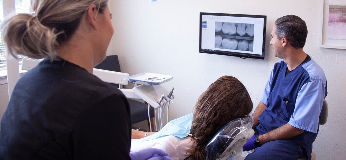Dentist and patient looking at digital x rays