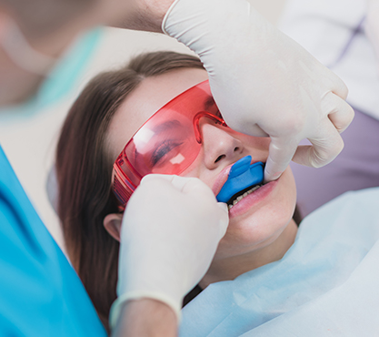 Dental patient with trays over her teeth