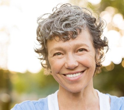 woman smiling after getting dentures