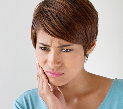 Woman in pain holding cheek