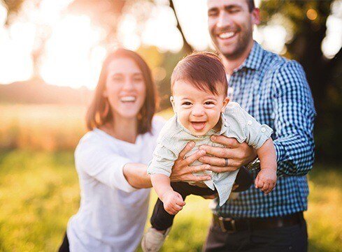 Mother father and child smiling outdoors