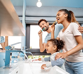 parents brushing their teeth with their child