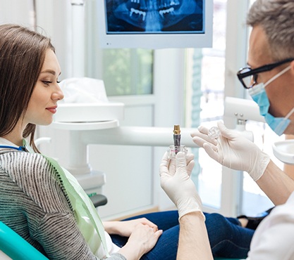 dentist showing a dental implant to a patient