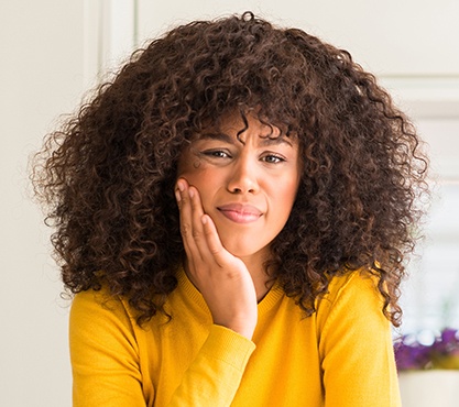 Woman in pain holding cheek