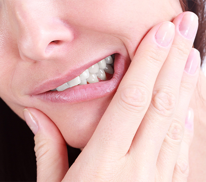 Closeup of grimacing person holding jaw