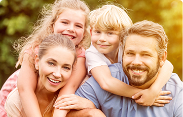 Smiling mother father and two kids outdoors