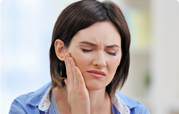 Woman in pain holding cheek