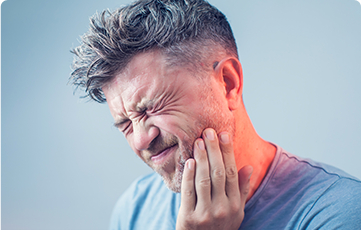 Grimacing man holding jaw