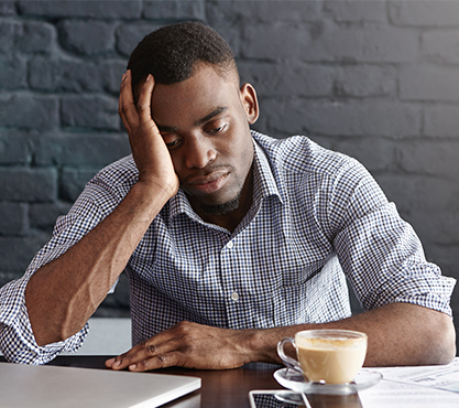 Tired man with head in hands