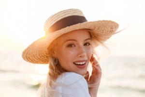 Smiling woman in sun hat at the beach