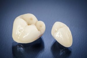 Two ceramic dental crowns on a blue background